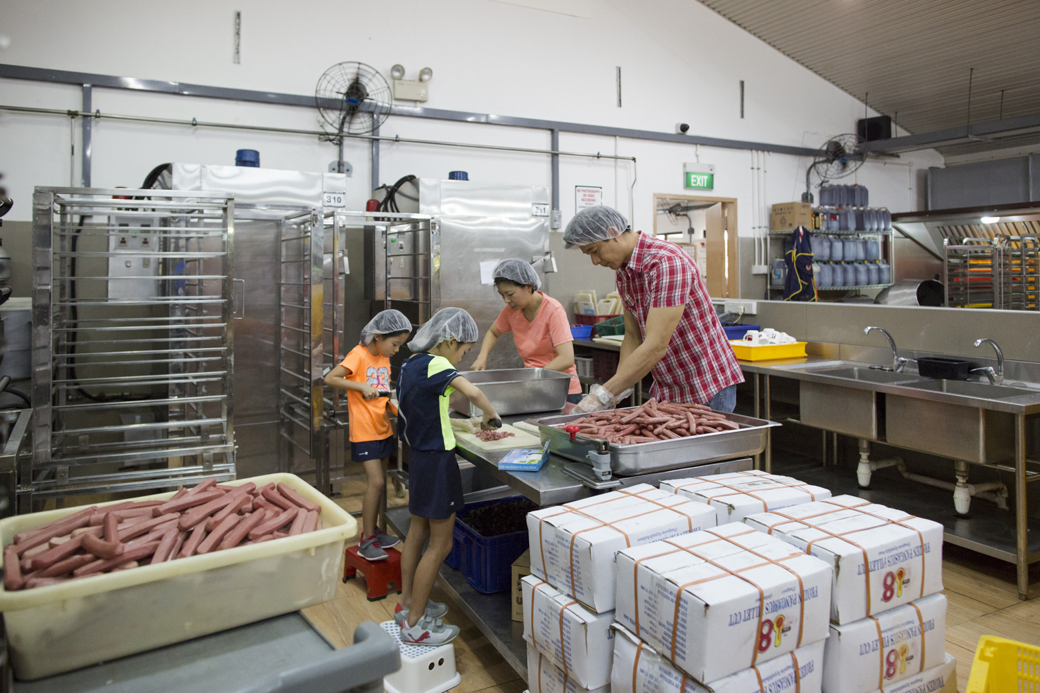 During the school holidays, the Tan family would embark on volunteering stints around Singapore. Here, the family helps with meal preparations at Willing Hearts, a volunteer-run soup kitchen that serves 5,000 meals a day.