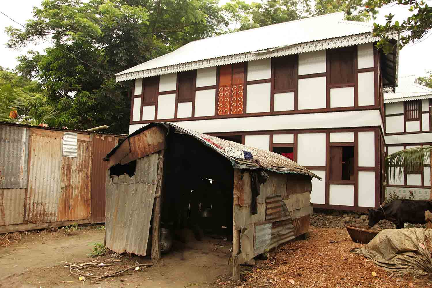 Markers of prosperity: a newly-built house and cows bought with his hard-earned money from working in Singapore