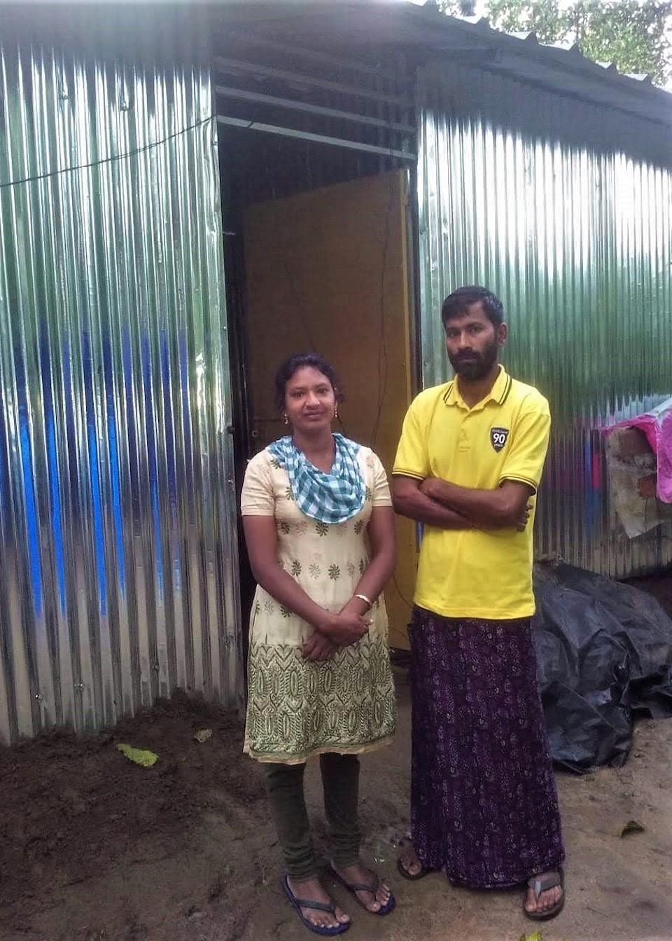 The house of Smitha and her husband A Ramesh (left)  was so badly damaged during the floods that they had to put up plastic sheets for walls in the aftermath. With the help of SaveAGram, they built a new home with tin walls. Photo courtesy of SaveAGram